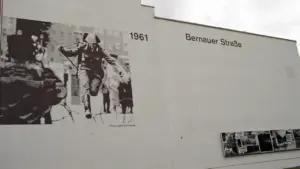 Gedenkwand in der Bernauer Straße mit historischem Foto eines DDR-Grenzsoldaten im Jahr 1961.