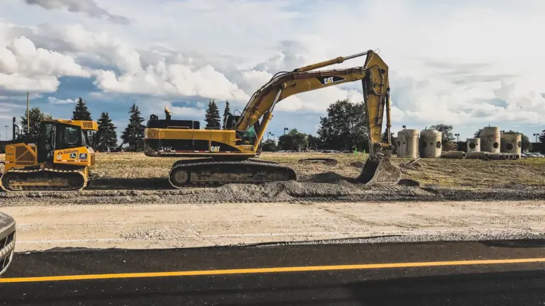 Baustellenfahrzeuge auf einer freien Fläche neben einer asphaltierten Autobahn bei Stuttgart