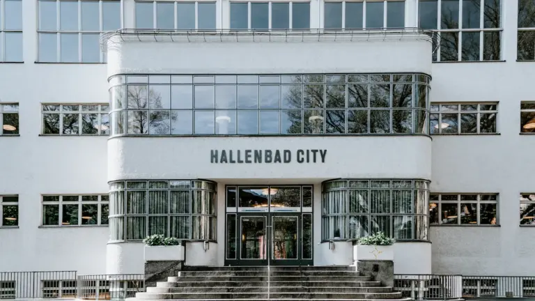 Die moderne Fassade des Hallenbads in der Stadt bei hellem Tageslicht.