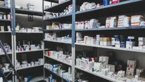 Vollgefüllte Regale mit Medikamentenpackungen in einer organisierten Apotheken-Umgebung.