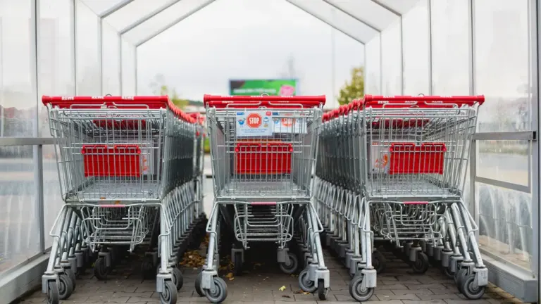 Reihen von Einkaufswagen in einem deutschen Supermarkt vor der Eingangshalle.