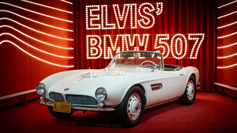 Elvis Presleys berühmter weißer BMW 507, ausgestellt auf einer roten Plattform für Besucher.