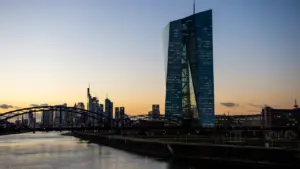 Die Europäische Zentralbank in Frankfurt mit Skyline bei stimmungsvollem Sonnenuntergang.