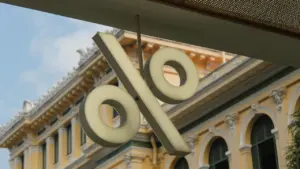 Ein großes, beleuchtetes Prozentzeichen vor einem klassischen Gebäude repräsentiert die EZB-Zinsentscheidung.