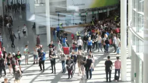 Junge Menschen betreten das Gamescom-Messegelände in Köln durch die große Eingangshalle.