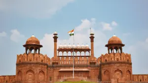 Indische Flagge weht über dem historischen Roten Fort unter einem blauen Himmel.