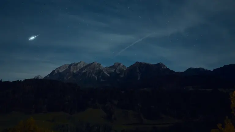 Sternenhimmel mit Mond und Sternen über einer malerischen Gebirgslandschaft in Bayern.