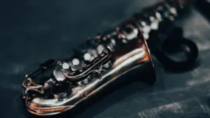 Nahaufnahme eines silbernen Saxofons auf schwarzem Hintergrund für kulturelle Berichterstattung.
