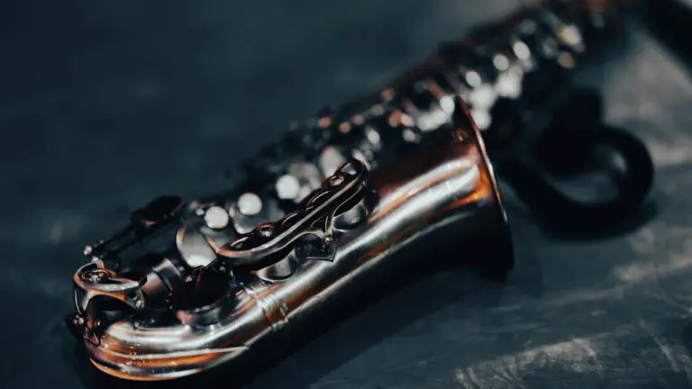 Nahaufnahme eines silbernen Saxofons auf schwarzem Hintergrund für kulturelle Berichterstattung.