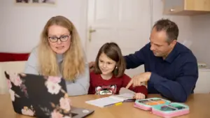 Eltern helfen ihrem Kind bei der Vorbereitung auf den bevorstehenden Schulbeginn am Schreibtisch.
