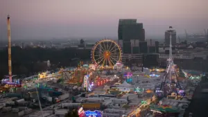 Weitwinkelaufnahme des Hamburger Doms bei Dämmerung mit beleuchtetem Riesenrad und Festgelände.