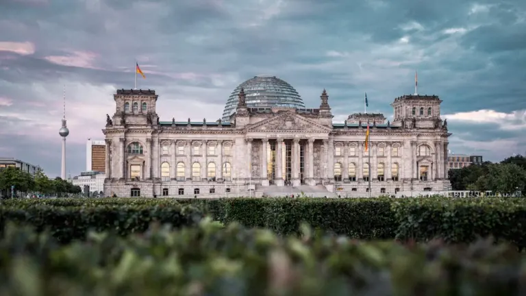 Das Berliner Reichstagsgebäude unter einem bewölkten Himmel bei Tageslicht.