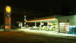 Eine nächtliche Shell-Tankstelle mit Schnee am Boden für einen Artikel über Kraftstoffpreise.