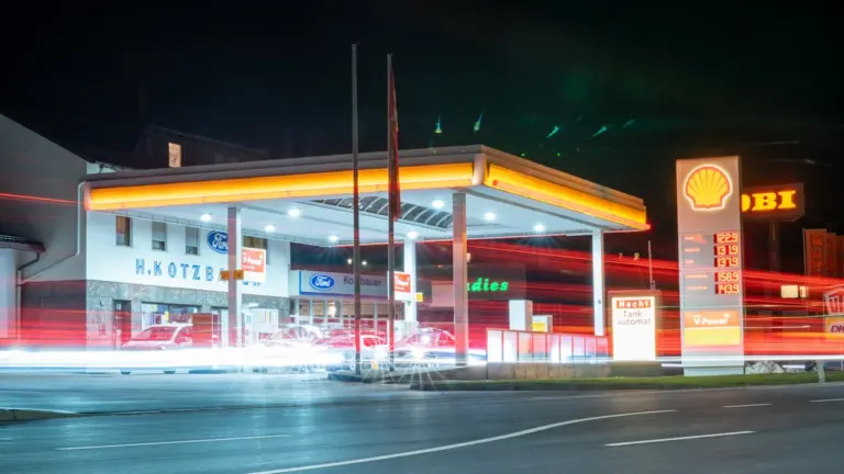 Eine beleuchtete Tankstelle in Deutschland bei Nacht mit gut sichtbarer Preistafel.
