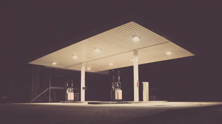 Eine beleuchtete Tankstelle bei Nacht in einer deutschen Stadtumgebung.